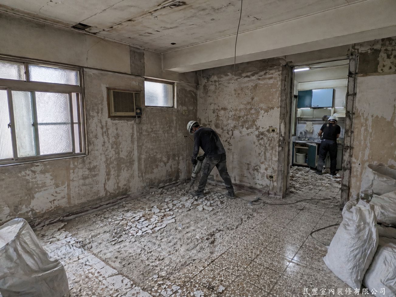 民豐室內裝修-客廳水電木作油漆地板暨廚浴翻新-師傅以電動打石機將全室磁磚地板全面拆除，另有師傅同步進行廚房翻新，工程團隊分工作業，提升施工效率