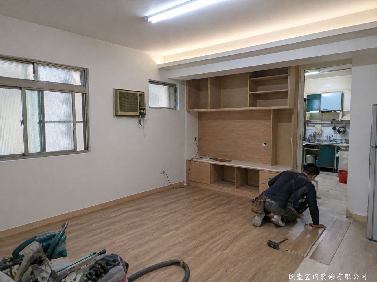 民豐室內裝修-客廳水電木作油漆地板暨廚浴翻新-牆面油漆完成後進行木地板鋪設，地面溫潤自然，天花板間接燈帶點亮，電視牆木作接近完成，空間質感已大幅提升