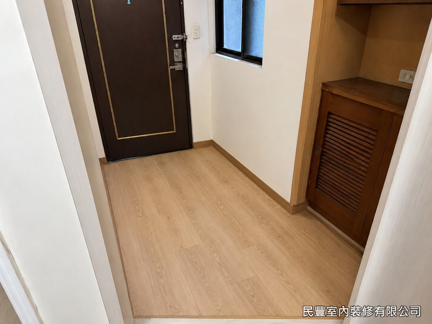 民豐室內裝修-SPC平鋪地板-完工後玄關木紋地坪溫潤明亮，耐磨防水好清潔，與深色門片相互襯托，民豐室內裝修快速交付質感入門空間