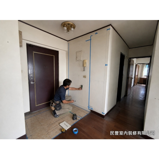 全室系統傢具裝修-師傅以雷射水平儀精確放樣，藍色膠帶標示系統櫃安裝位置與尺寸，確認玄關收納牆面的完整規劃，為後續系統板材安裝建立精準基準線