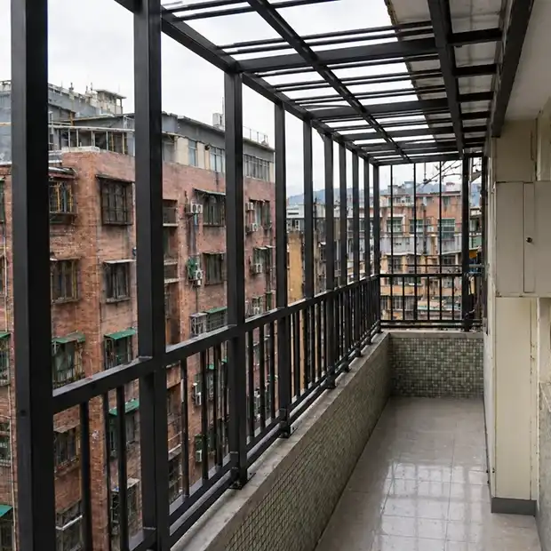 鐵工工程-完工實景，工程完工後，整體陽台空間煥然一新。新型鋁合金玻璃帷幕圍封取代了原有老舊鐵架，視覺更加簡潔現代；玻璃透光設計確保室內採光不受影響，同時有效阻擋風雨及灰塵